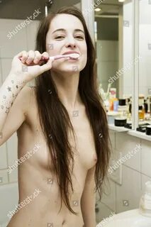 MODEL RELEASED Young woman nude brushing her Redaksjonelt ar