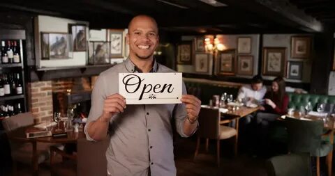 Portrait of smiling caucasian waiter holding sign. - Royalty