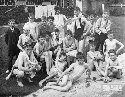 Boys from a Boys Club sit after their swim by the edge of a swimming pool, Stock