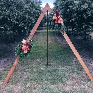 Triangle wedding arch with wild Australian flowers Find via 