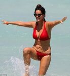Patti Stanger pours out of crimson bikini as she steps into 