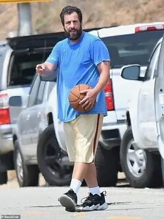 Adam Sandler sweats while wearing an oversized tee and short