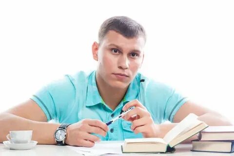 Male student sitting at the table with books Stock Photo by 