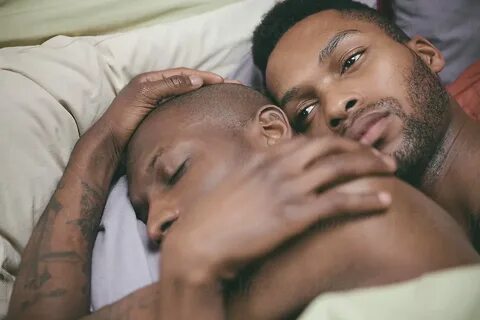Black Gay Man In Reflective Mood Holding His Lover In Bed by