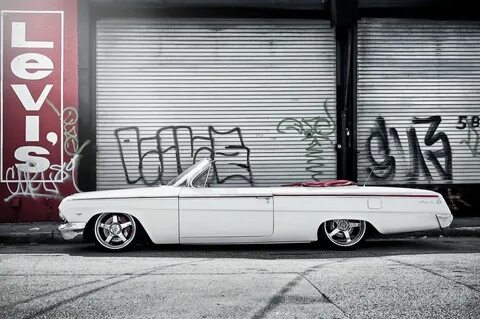 Стильный белый кабриолет Шевроле импала на фоне граффити Обо