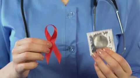 doctor showing red ribbon condom international: стоковое вид