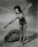 Annette Funicello in a swimsuit and high heels, with a paddl
