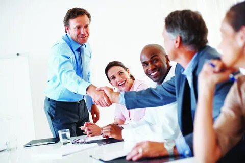 Mature team leader shaking hands with colleague during prese