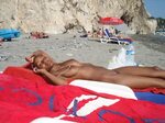 Чернокожая девушка лежит полностью голой на пляже
