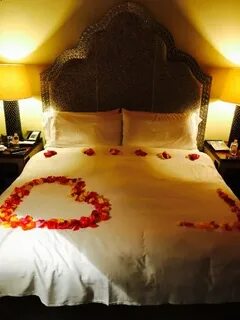 Romantic Turndown with rose petals and candles. - Picture of