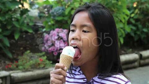 Young Asian Girl Eating Ice Cream Cone.