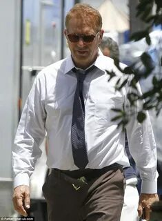 Kevin Costner checks his watch on set of Black And White Dai