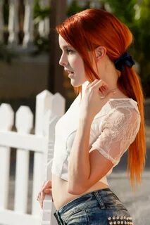 Redhead strips near a white fence - Pichunter