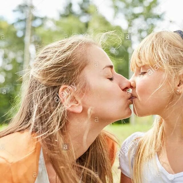 May be an image of 2 people, child, people kissing, people standing, outdoo...