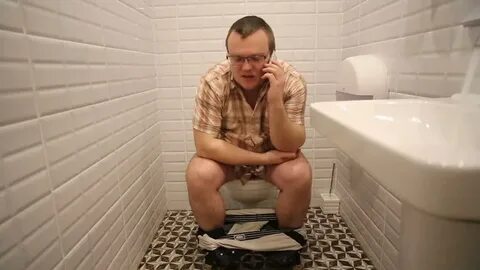 man sits on toilet talking phone: стоковое видео (без лиценз