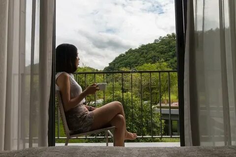 A Short Hair Young Woman Sitting at the Balcony Stock Photo 