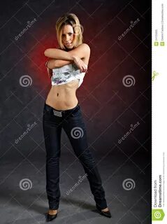 Photo about Full length shot of young woman taking off her clothes sexually...