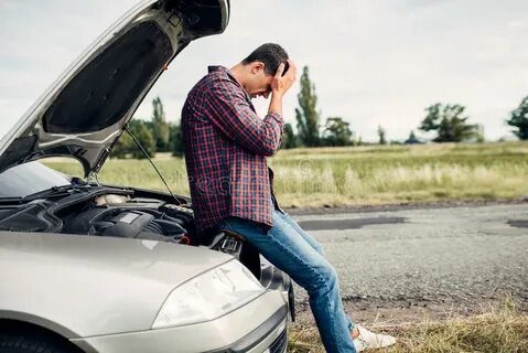 Depressed Man Sitting on a Hood of Broken Car Stock Image - 