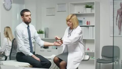 Mid Adult Female Doctor Manually Checks Male Patient's Pulse