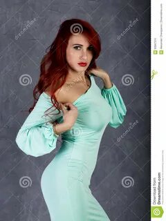 Portrait of Beautiful Redhead Young Woman with Big Boobs in a Turquoise Dress on
