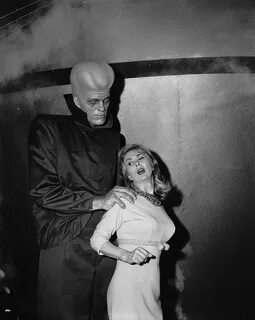 Richard Kiel grabs actress Susan Cummings from behind in a scene from the &...