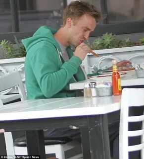 Tom Felton is casual in hoodie and baggy trousers as he take