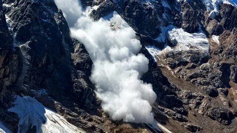 Avalanche flowing down mountain.