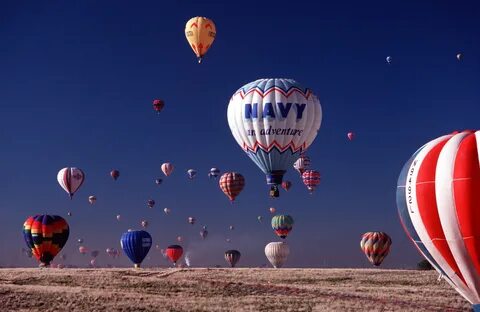 The Navy hot air balloon, along with several others, rises i