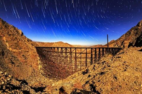 Star Trails Over the Goat Canyon Trestle Illuminated by a . 