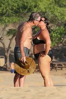 Pierce Brosnan and bikini clad wife Keely Shaye Smith kiss o