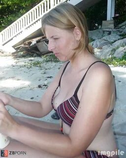 Girl at the beach in her beach wear applying lotion 