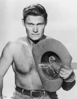 Studio portrait of American actor Chuck Connors , barecheste