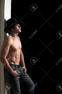 Shirtless Cowboy Leaning Against A White Wall 2 Stock Photo,