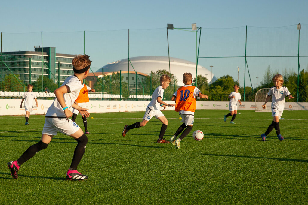 дети играют в футбол на поле академии