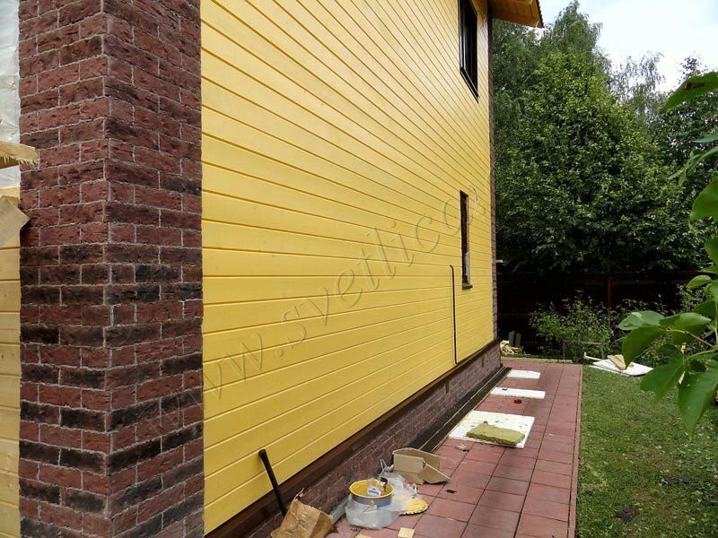 Отделка фасада дома имитацией бруса и камнем - фото