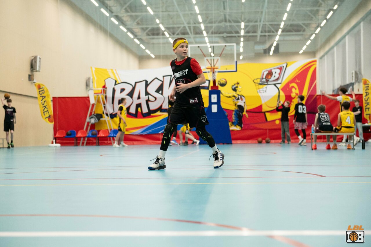Подросток с мячом в зале с граффити iBasket