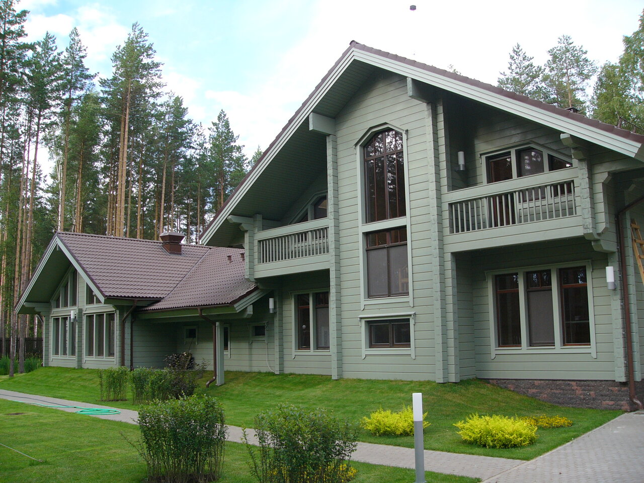 Зеленый деревянный дом с белыми окнами