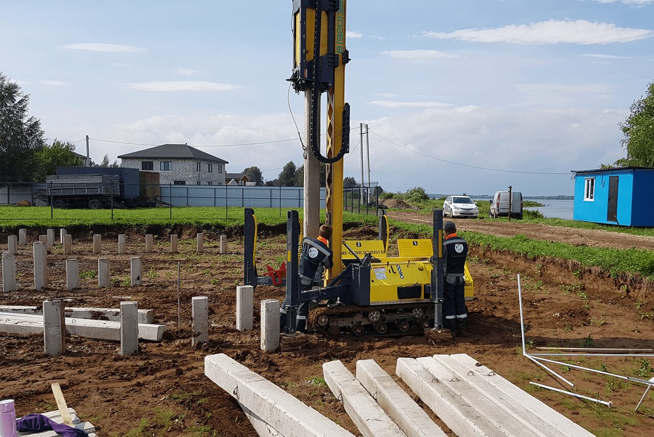 Забивает сваи на стройке