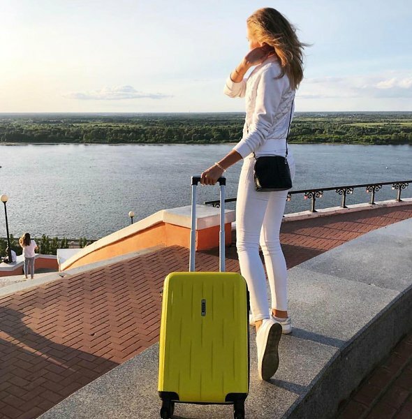 Девушка с открытым чемоданом на колесиках