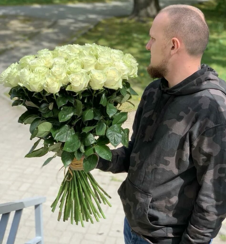 Парень с огромным букетом белых роз