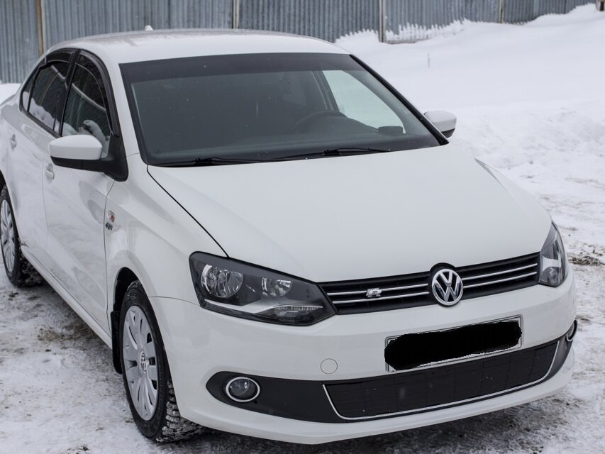 Белый седан Volkswagen Polo зима