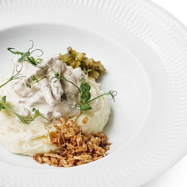 Бефстроганов из говяжьей вырезки с пюре, моченой брусникой и луковыми чипсами