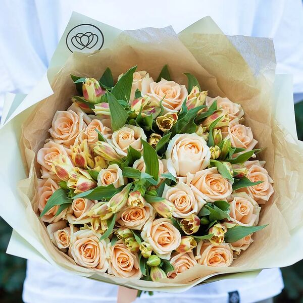 Букет из 26 кремовых роз 35-40 см (Россия) и 7 оранжевых альстромерий в зеленой пленке