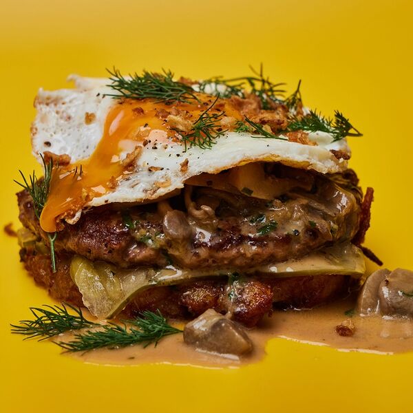 Бифштекс с картофельным драником с пармезаном, грибным рагу и глазуньей.