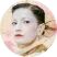Женщина с тёмными волосами, светлым макияжем и красной помадой, в одежде пастельных тонов с цветочным декором