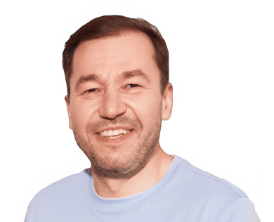 Man with short brown hair, light stubble, smiling, wearing light blue t-shirt