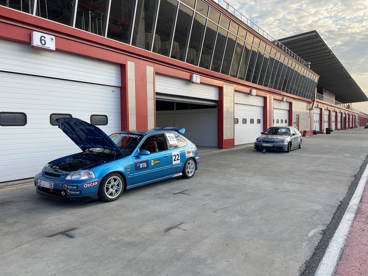 Машины на автодроме готовятся к очередному заезду.