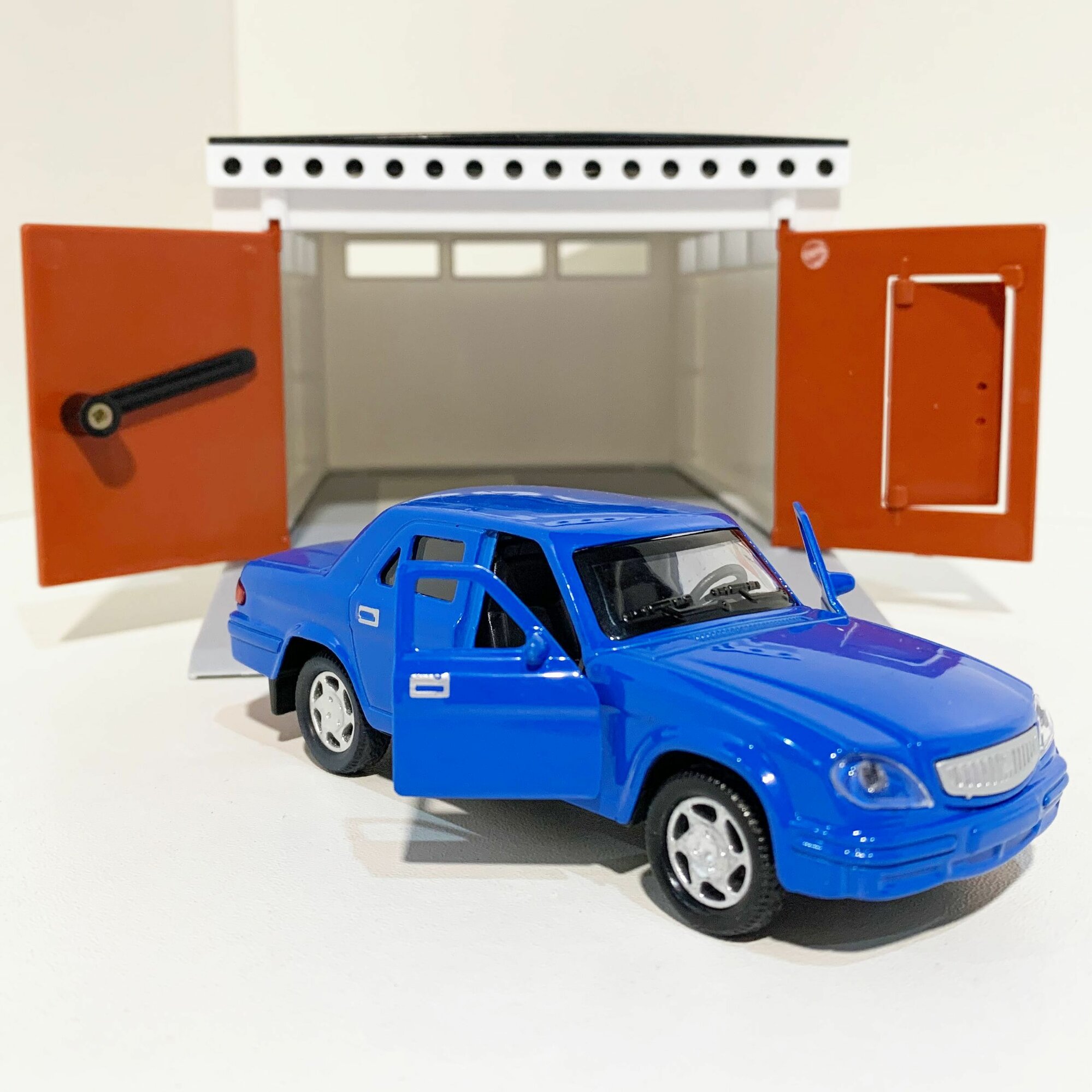 фото Гараж с распашными воротами и металлическая инерционная машинка Волга 3110 с 2-мя открывающимися дверями (12 см) - голубая