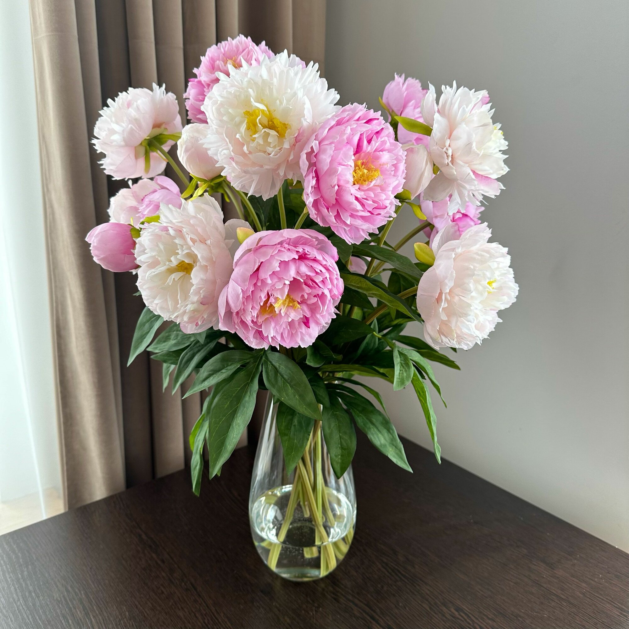 фото Букет из 7 премиальных розовых и нежно-розовых пионов в стеклянной вазе с имитацией воды