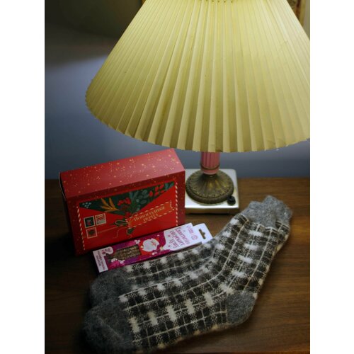 Новогодний подарок: уютные носки и трубочки для глинтвейна с открыткой и подарочной коробкой новогодняя коробка с новым годом дерево елка красный фон